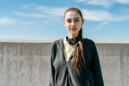 confident beautiful girl in black stylish clothes posing under the blue sky, doing sports and runningの写真素材