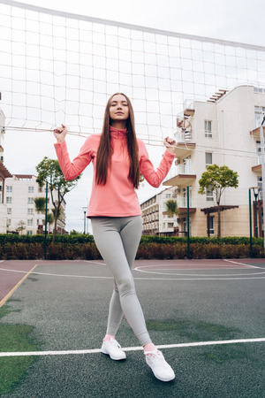 confident sports girl playing volleyball in the open air, leads an active lifestyleの写真素材