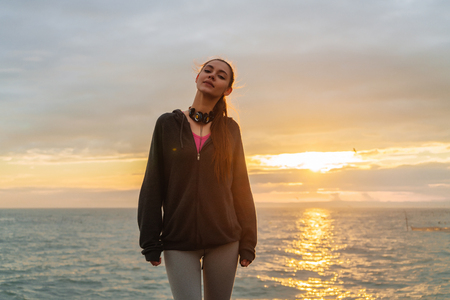 confident sports girl running around the seaside at sunset, wants to lose weightの写真素材
