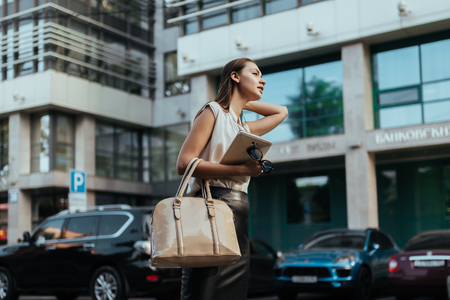 Young business lady catches a taxi at work in a harryの写真素材