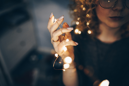 hand that holds glowing garlands close upの写真素材