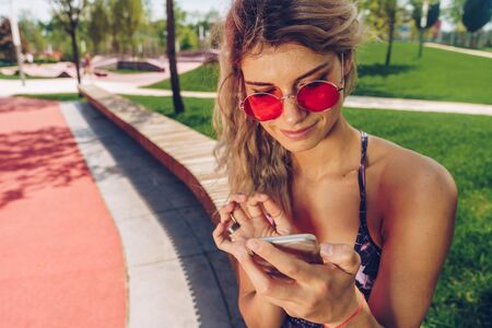 sportswoman crouched in the park and writes SMSの写真素材