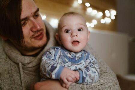 young father holds baby in his arms