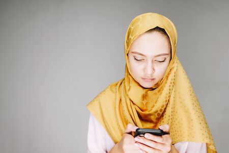 modest muslim woman is telephoning in her hand