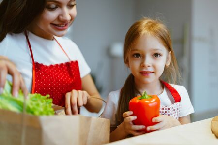 mom and daughter are sorting vegetables in the kitchenの写真素材