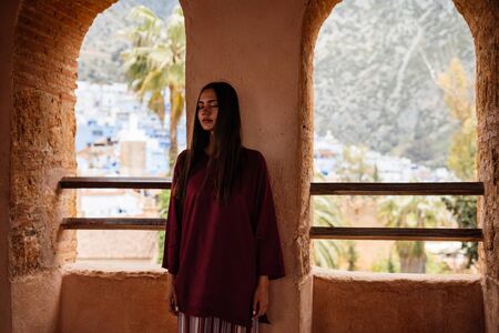 The girl hid in a wall between the windows in the premises of the old castleの写真素材