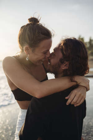A bright couple in love with a man lifted the girl as she wrapped her arms around his neck their...