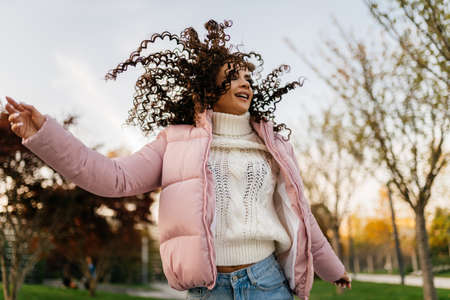 Playing hair turns heads in the park with her arms spinning girl. High quality photo
