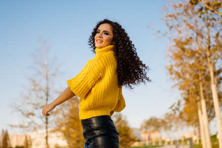 Girl whirls in park showing off her long curly hair flying beautifully in flight. High quality photoの写真素材