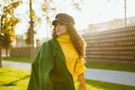 Beautiful girl in stylish autumn clothes is fast walking through the park in autumn. High quality photoの写真素材