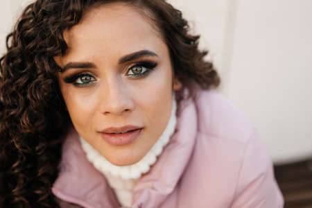 Close-up face female very beautiful expressive eyes with makeup figs and luxurious plump lips of a...
