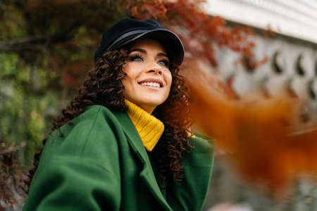 Proud arrogant look and smile of the winner in a cap with long dark curls falling on her shoulders....