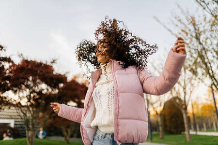 flying in the air curls of dark hair at a girl jumping in the park. High quality photoの写真素材