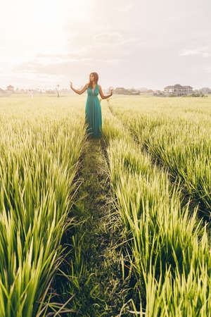 Among the rice landings on the track comes a girl in a long dress. High quality photoの写真素材