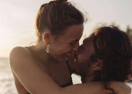 close-up man and woman laughing and bringing faces to each other touching noses. High quality photo