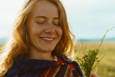 closing her eyes and smiling tenderly holding in his hand a bouquet of red-haired girl with freckles...