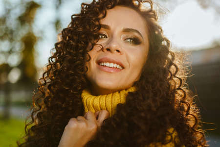 close-up of the face of a girl with green eyes in the sunset gently smiling. High quality photoの写真素材