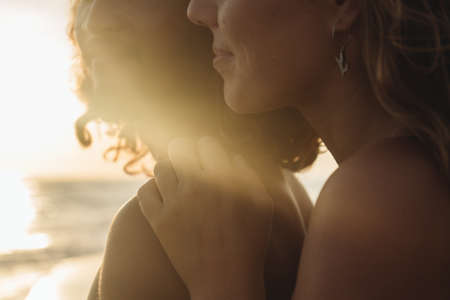 close-up of the lower parts of the faces smiling in the sun of a man and a woman against the ocean. High quality photoの写真素材