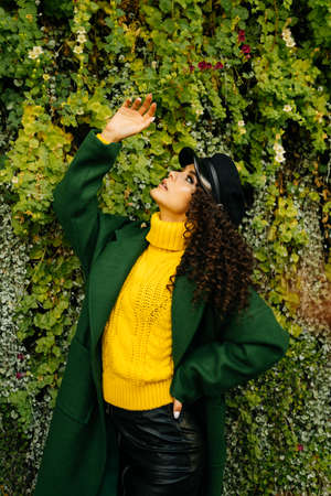 Beautiful stylish woman touches her hand leaves ivy coming down cascade down. High quality photoの写真素材