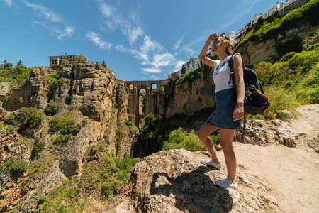 Tourist girl on the background of the famous bridge in Ronda, Spainの写真素材