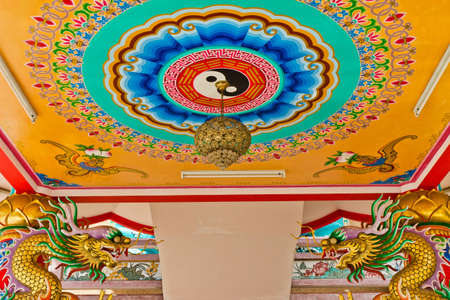 A statue of a dragon on a pole in the Chinese temple in the daytime.の写真素材