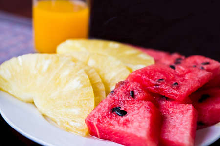 Orange juice and fruit in the dish on the dining table.の写真素材