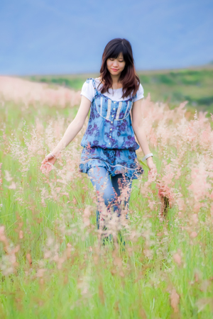 women walk in  flowering grassの写真素材