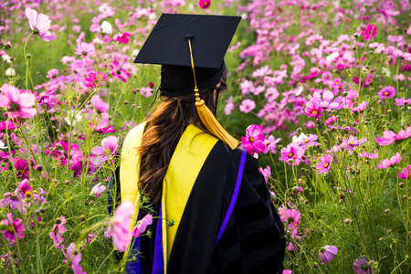Back of Girl Graduate Among Beautiful Flowerの写真素材