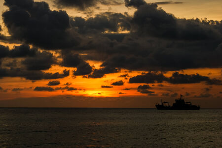 ship sailing into the sunsetの写真素材