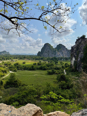 A breathtaking panoramic view of Kampong Trach Mountain Park in southern Cambodia, showcasing its dramatic limestone karst formations, lush greenery, and natural beauty. This scenic and relatively unexplored area near Kep offers travelers a peaceful retreat surrounded by towering cliffs and unique geological features.の写真素材