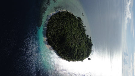 Aerial view of uninhabited small islands in West Waigeo, surrounded by vibrant coral reefs and crystal-clear turquoise waters.の写真素材