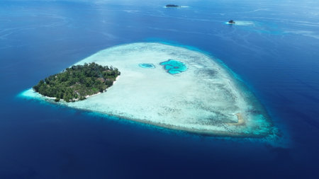 Aerial view of uninhabited small islands in West Waigeo, surrounded by vibrant coral reefs and crystal-clear turquoise waters.の写真素材