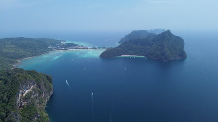 Secluded beach with turquoise water, white sand, and dramatic cliffs on Phi Phi Don Island, ideal for snorkeling and nature lovers.の写真素材