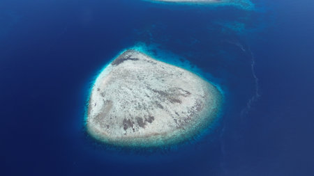 Aerial view of uninhabited small islands in West Waigeo, surrounded by vibrant coral reefs and crystal-clear turquoise waters.の写真素材