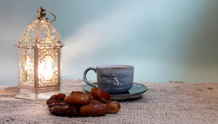 Traditional Iftar setting for breaking the fast during Ramadan with a glowing fanous lantern, sweet dates, and a warm cup of coffeeの素材