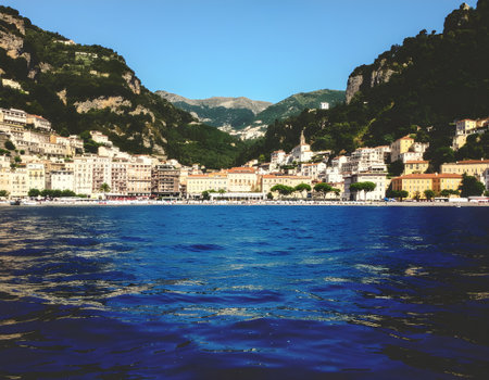 Scenic view of a picturesque coastal town on the Mediterranean Riviera from the vibrant blue sea on a sunny dayの素材