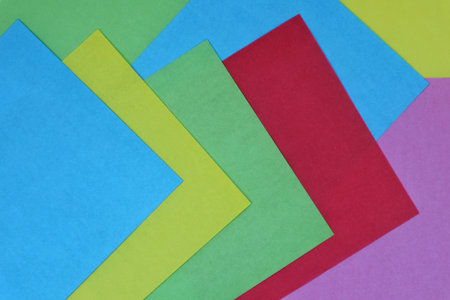 A vibrant abstract composition created by overlapping sheets of purple, yellow, green, red, and blue...