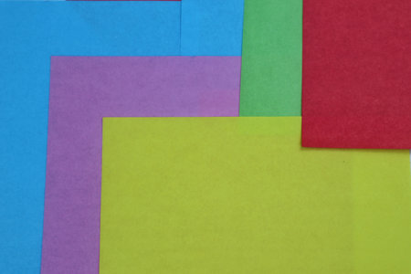 An abstract symmetrical design featuring red, blue, green, and yellow colored paper, with yellow being the dominant hue, creating a balanced and vibrant composition.の写真素材