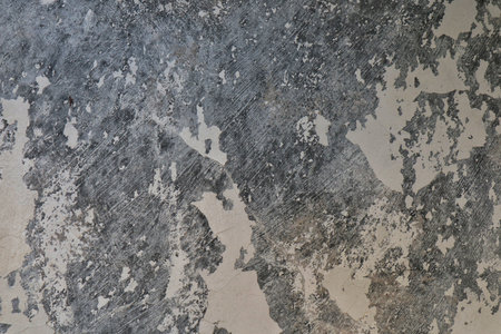 A close-up of a heavily textured surface, resembling old, weathered concrete or plaster, with visible imperfections and a rugged, industrial feel.の写真素材