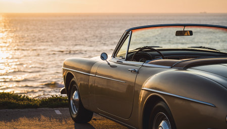 Golden Classic Convertible Car on Coastal Road at Sunsetの素材