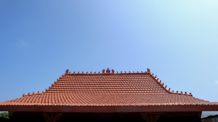 Traditional cultural building roof with terracotta tiles under clear blue sky