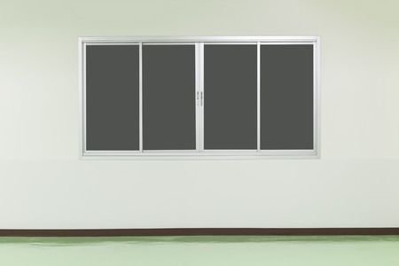 Empty white wall with green floor and window background.