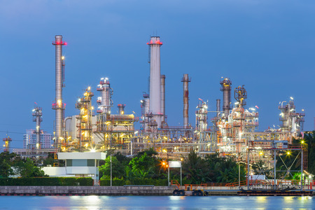 Oil refinery at twilight with sky background.