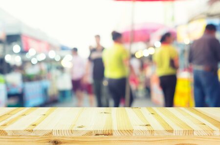 Blurred photo of food exhibition fair montage with wood table top for background.の写真素材