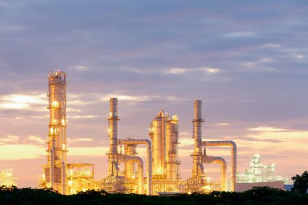 Oil refinery plant at twilight with sky background.