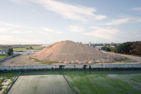 Pile of sand in concrete plant with sky background. Heap of aggregate or material from nature, mine or quarry for mix with cement, concrete for industry construction work.の写真素材
