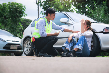 Accident, crash or collision of auto car, bicycle at outdoor. Include people i.e. insurance officer and young girl or bicycle rider to injury on road. Concept for insurance claim.の写真素材