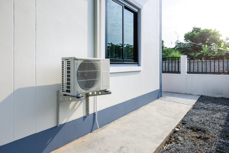 Condenser unit or compressor outside home or residential building. Unit of central air conditioner AC or heating ventilation air conditioning system HVAC.の写真素材