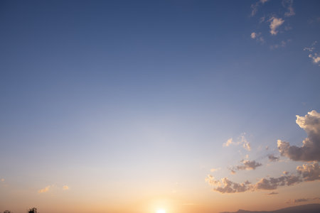 Beautiful sky, sun and cloud at high. Include space, light of nature, sunset, sunrise. Colorful with yellow, orange and blue color at evening time in autumn for scene background.の写真素材