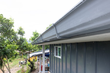 Gray pvc roof gutter in perspective install at edge roof sheet on building with gravity slope for...